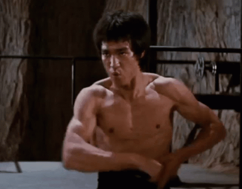 Bruce Lee effortlessly twirling nunchucks with absolute precision.