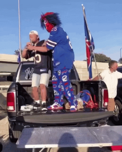 A group of Bills Fans from the infamous Bills Mafia dramatically hurl someone onto a table.